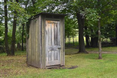 Bir park ortamında açık bir tuvalet mevcuttur.