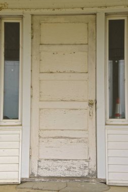 Eşleşen pencereler arasında ağır bir eski beyaz ev kapısı.