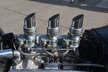 Bir ağaç arabasının motorunda üç set krom karbüratör.