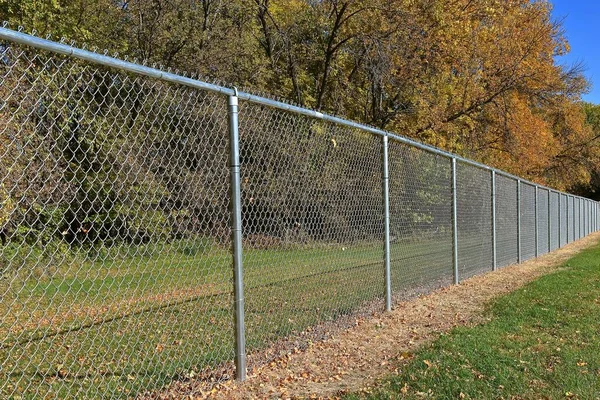 一个新建的带有链环篱笆的狗公园 四周环绕着秋天的树叶 — 图库照片