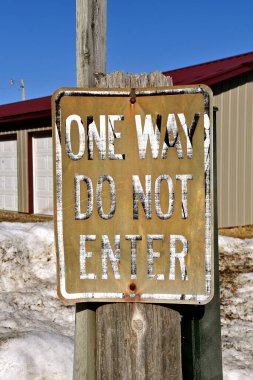 Tek yönlü eski bir grunge Girilmez işareti bir sıra garajın önüne asılır.