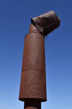 Paslı bir teneke kutu çok eski bir traktörün egzoz susturucusunu kapatır, böylece motoru yağmurdan kuru tutar.