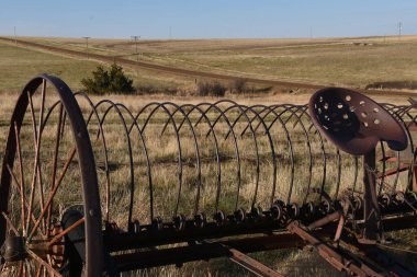 Saman toplamak için eski bir çöp tırmığı bahar çimlerine park edilmiş.
