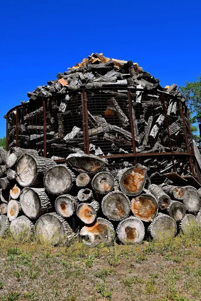 Stapelweise Gestapelte Baumstämme Und Gehäckseltes Brennholz Werden Einer Alten Käfigkrippe — Stockfoto