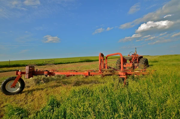 Trator e ancinho no campo — Fotografia de Stock