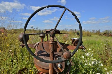View through a rusty old tractor steering wheel clipart