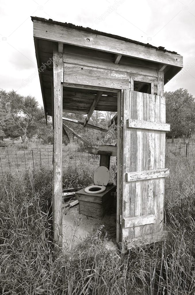Black and White) Rickety falling apart outhouse