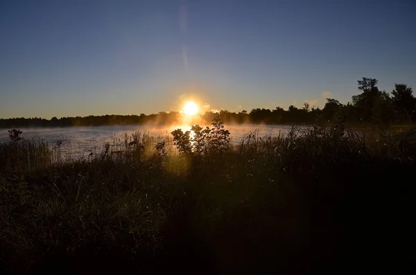 Zonsopgang boven een lake en de kustlijn — Stockfoto