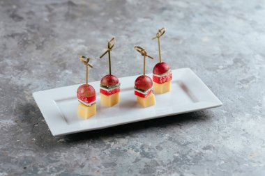 Peynirli kanepe ve tabakta vişneli domates.