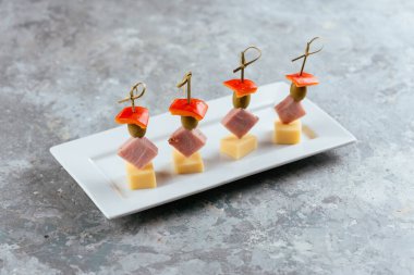 Tabakta et ve peynir olan kanepe.