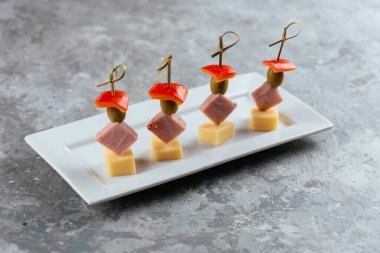 Tabakta et ve peynir olan kanepe.