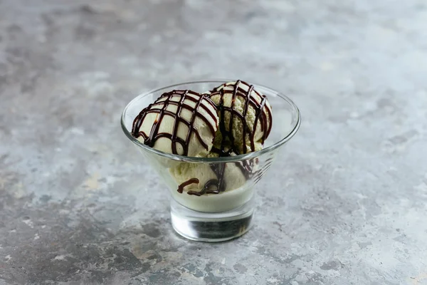 chocolate ice cream in glass jar on grey background