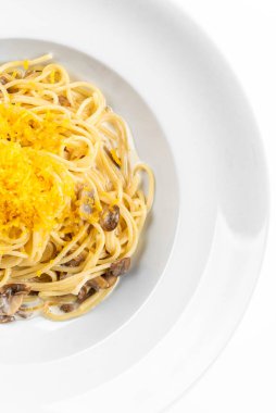 Mantarlı İtalyan makarnası, krema sosu, beyaz arka planda çedar peyniri.