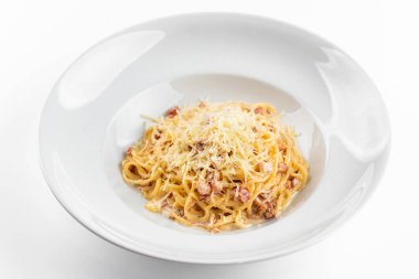 Pastırmalı İtalyan makarna, yumurta, yalıtılmış beyaz arka planda parmesan peyniri.