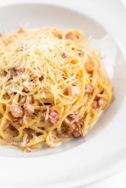 Pastırmalı İtalyan makarna, yumurta, yalıtılmış beyaz arka planda parmesan peyniri.