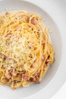 Pastırmalı İtalyan makarna, yumurta, yalıtılmış beyaz arka planda parmesan peyniri.