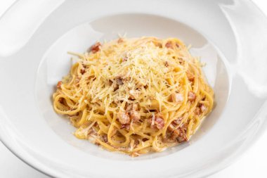 Pastırmalı İtalyan makarna, yumurta, yalıtılmış beyaz arka planda parmesan peyniri.