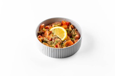 Sebzeli baharatlı deniz ürünleri çorbası ve beyaz arka planda baharatlar.