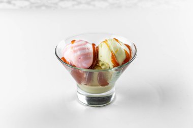 Beyaz arka planda cam bir kasede dondurma.