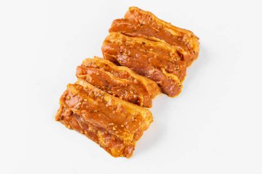 Beyaz arka planda baharatlı marine edilmiş et.