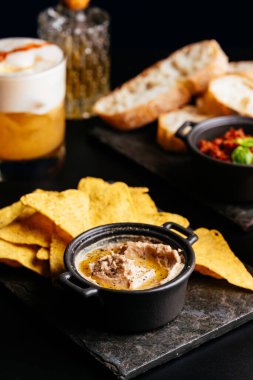 Salsa soslu Meksika cipsi ve siyah arka planda mısır cipsi.