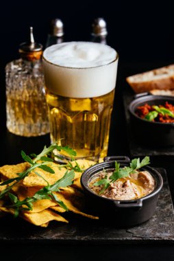 Siyah arka planda tavuk ve sebzeli bira..