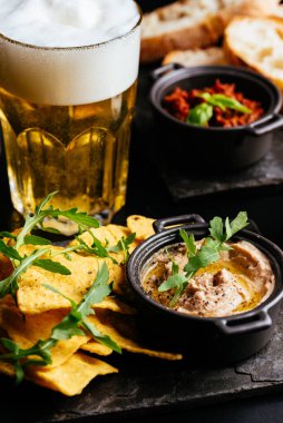 Bira ve atıştırmalıklar ahşap bir masada..