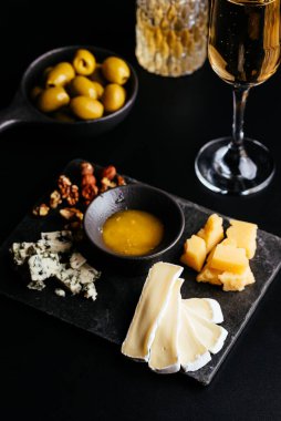 Siyah arka planda bal ve üzümlü peynir