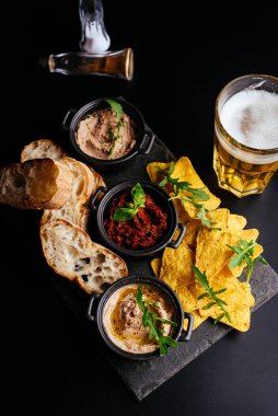 Siyah arka planda bira ve atıştırmalıklar 