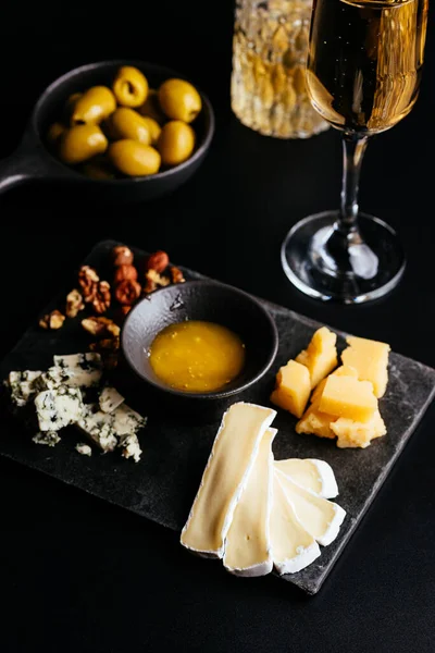 Queijo Com Nozes Uvas Sobre Fundo Preto — Fotografia de Stock