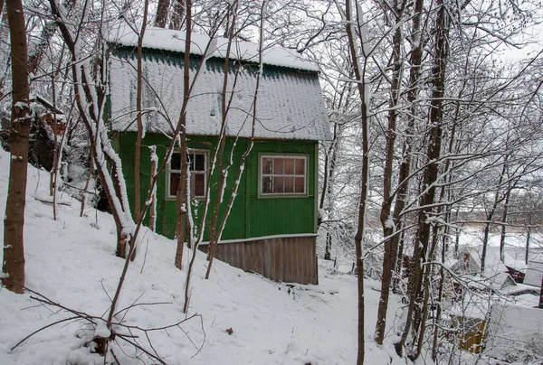 Scène d'une forêt d'hiver et d'un village authentique avec de vieilles maisons en bois recouvertes de neige. — Photo