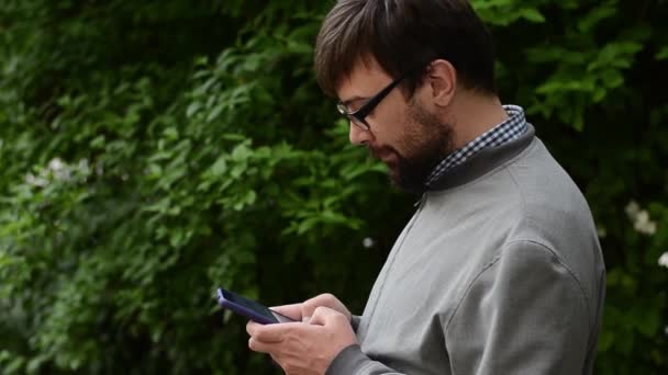 Joven escribiendo sms en el teléfono — Vídeo de stock