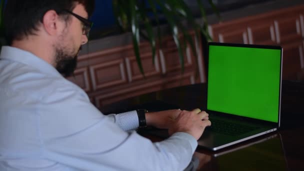 Écran de maquette vert sur l'homme de l'ordinateur portable assis — Video