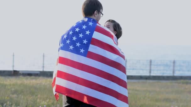 Szczęśliwa młoda amerykańska para stojąca z flagą USA na ulicy świętująca dzień niepodległości — Wideo stockowe