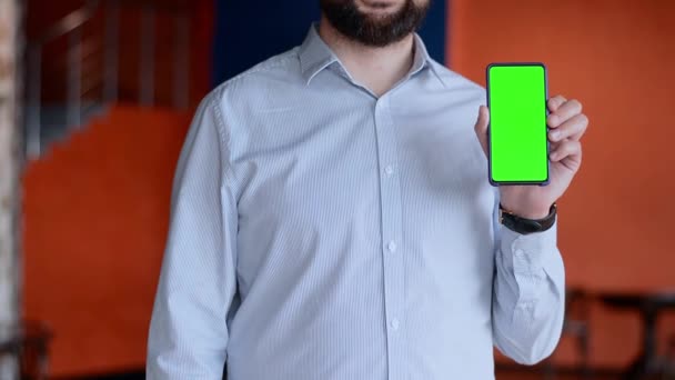 Green-Screen-Telefon isoliert auf lila Hintergrund in den Händen eines Mannes — Stockvideo