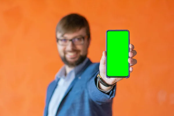 Πράσινη οθόνη mocap τηλέφωνο στα χέρια ενός νεαρού επιχειρηματία θολούρα Εικόνα Αρχείου