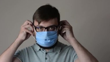 Yüzüne koruyucu maske takan, sakallı, çekici, kahverengi saçlı bir adamın yakın plan portresi.