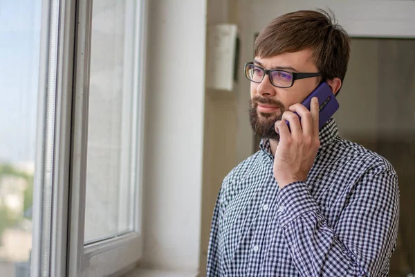 Telefonda konuşan yakışıklı bir iş adamının yakın plan portresi.