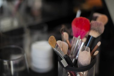 Bulanık bir arkaplanda profesyonel makyaj fırçaları.