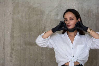 Siyah maskeli ve siyah eldivenli güzel bir kadın.