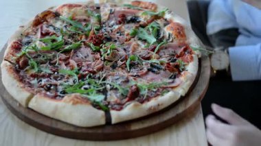Genç eller, sebzeli, domatesli, pepperonili, lezzetli yemeklerden zevk alan bir dilim pizza alır. 