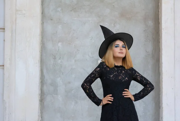 Mujer joven gótica feliz disfraz de bruja de Halloween con sombrero sobre fondo gris —  Fotos de Stock