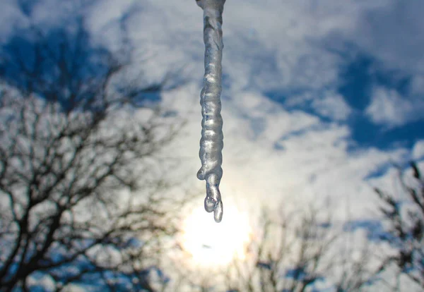 Gökyüzünün arka planında güneşli bir kış gününde bulutlarla sarkıt