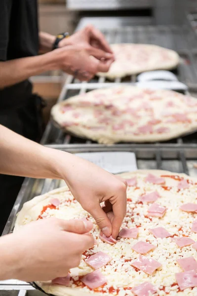 Lähikuva Kaksi Ammatillista Kokkia Valmistelee Pizzoja Pystysuora Kuva Pikaruoka Käsite — kuvapankkivalokuva