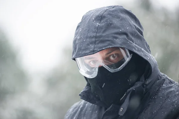 Jongeman Uitgerust Met Winterkleding Sneeuwstormbril Kijkend Naar Camera Een Sneeuwstorm — Stockfoto