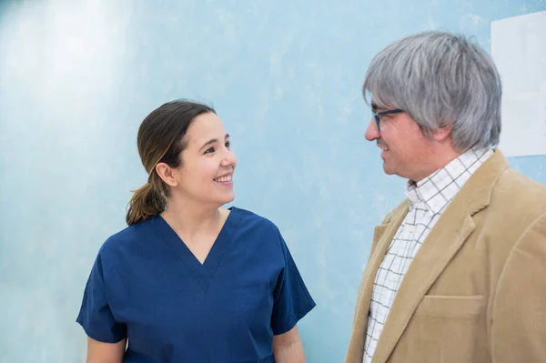 Young, smiling woman doctor chatting with middle-aged patient in dental clinic.Health care and medicine concept