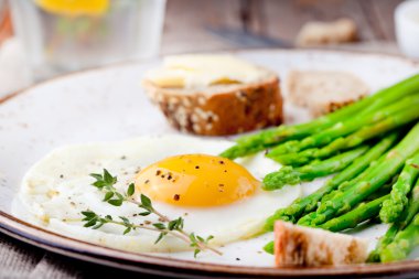 Yeşil kuşkonmaz, kızarmış yumurta ve ekmek tereyağı ile.