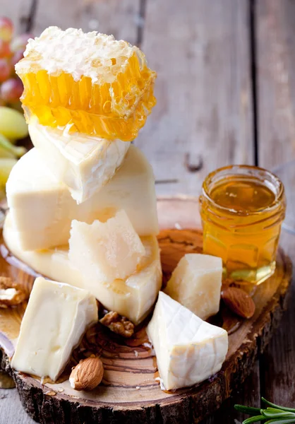 Trauben, Käse, Feigen und Honig mit einem Glas Wein. Stockbild