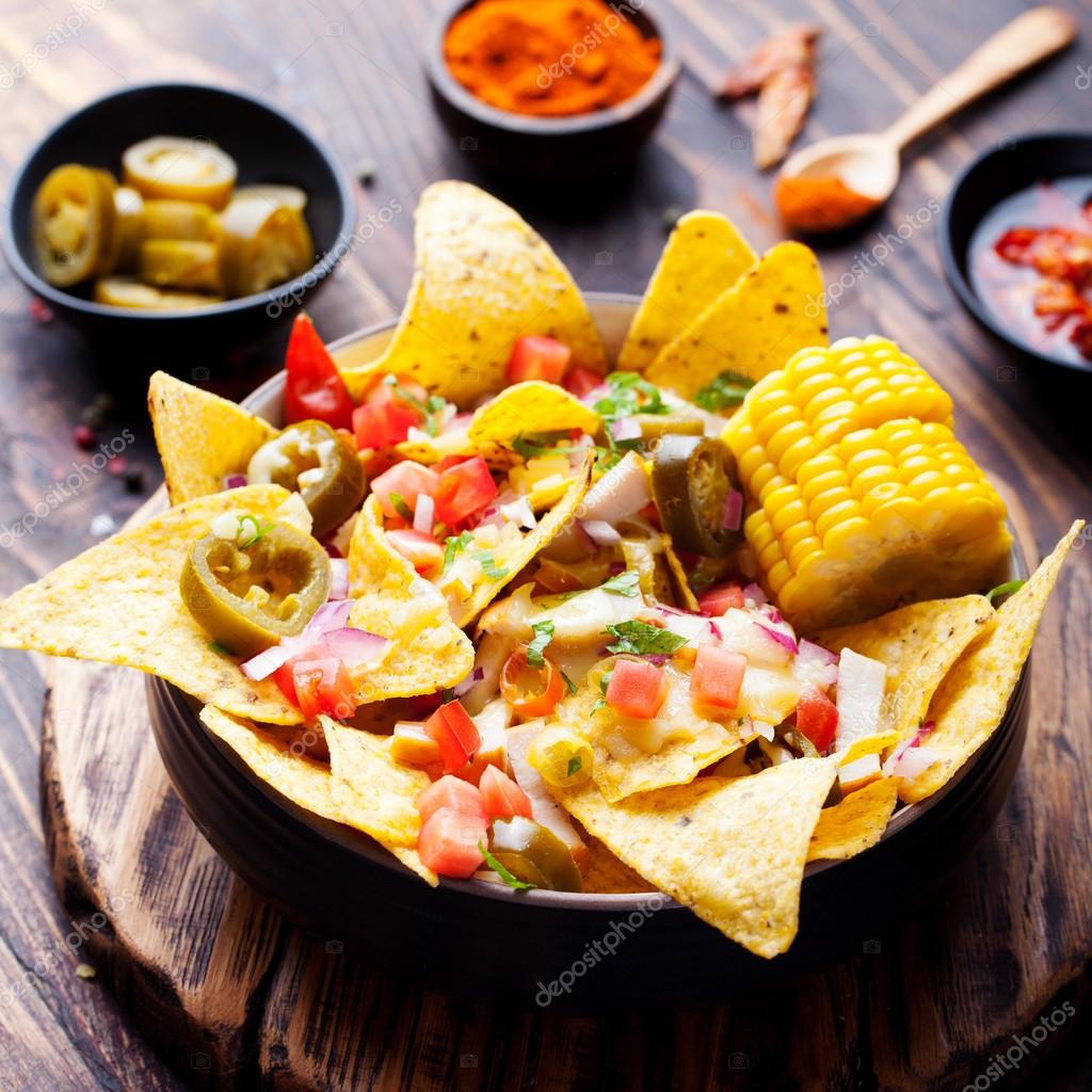Tortilla nachos, cheese sauce, chicken, jalapeno, tomato, salsa, corn