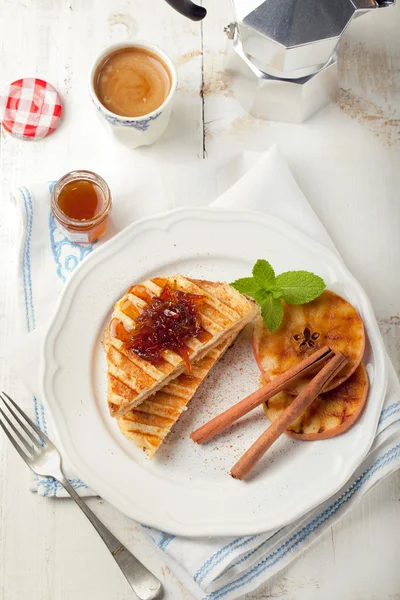 French toasts with orange marmalade, grilled apples and cinnamon sticks.